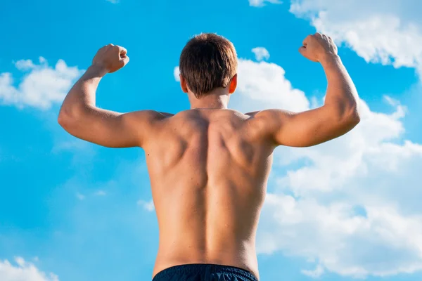 The won person with the raised hands against the sky. view from a back — Stock Photo, Image