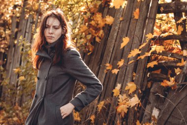 üzgün kadın karşı bir çit ve akçaağaç yaprakları