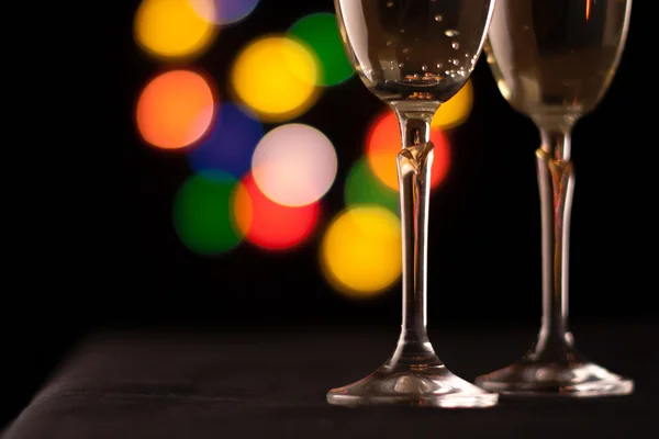 Two glasses of champagne toasting against bokeh lights background — Stock Photo, Image