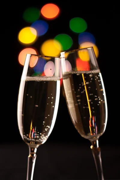 Two glasses of champagne toasting against bokeh lights background — Stock Photo, Image