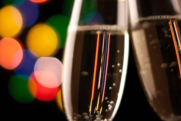 Two glasses of champagne toasting against bokeh lights background — Stock Photo, Image