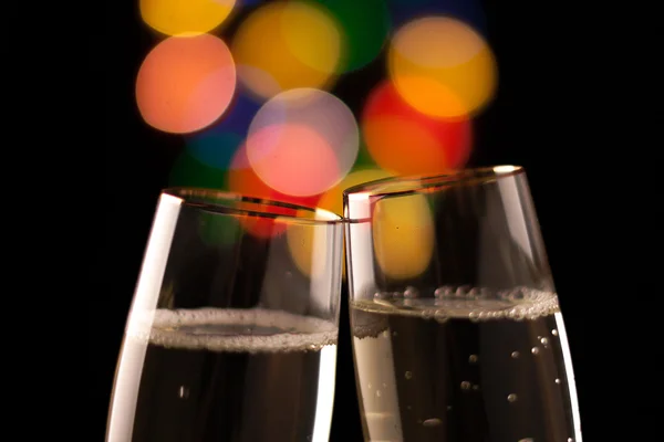 Dos copas de champán tostadas contra fondo de luces bokeh —  Fotos de Stock