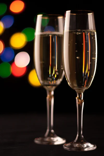 Dos copas de champán tostadas contra fondo de luces bokeh — Foto de Stock