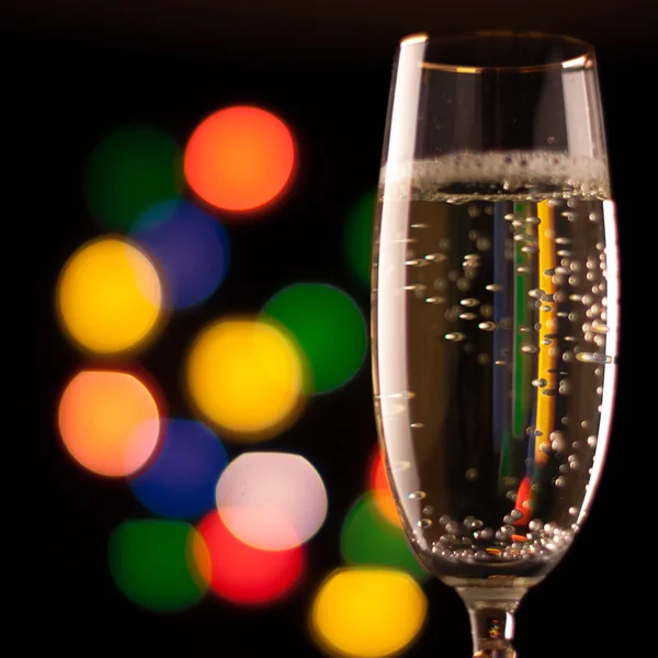 Two glasses of champagne toasting against bokeh lights background — Stock Photo, Image