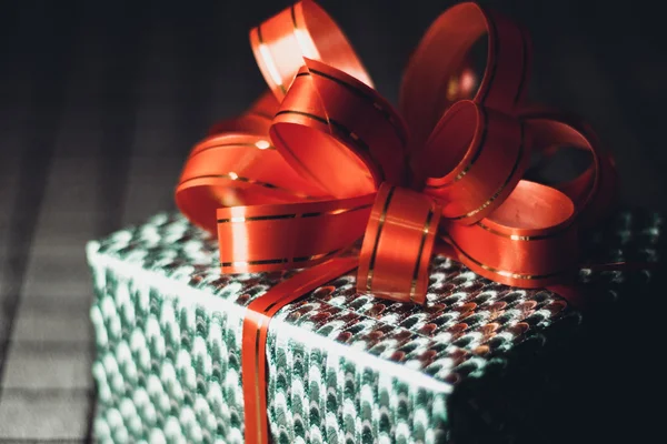 Caja de regalo verde con una cinta roja en primer plano de fondo —  Fotos de Stock