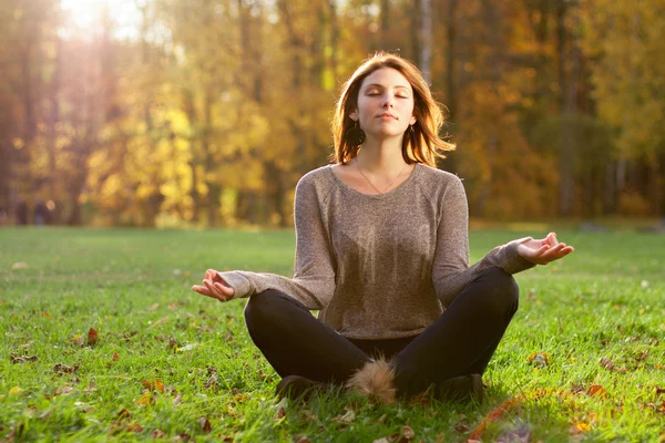 Piękna młoda dziewczyna medytująca w jesiennym parku — Zdjęcie stockowe