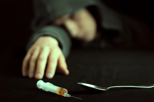 Grunge obraz deprese narkoman, při pohledu na injekční stříkačku a drogy — Stock fotografie