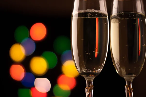 Twee glazen van champagne roosteren tegen bokeh lichten achtergrond — Stockfoto