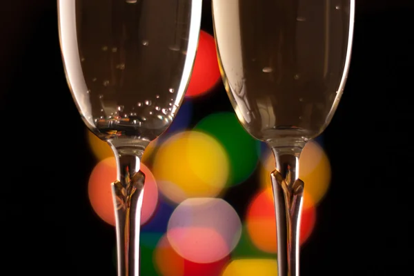 Twee glazen van champagne roosteren tegen bokeh lichten achtergrond — Stockfoto