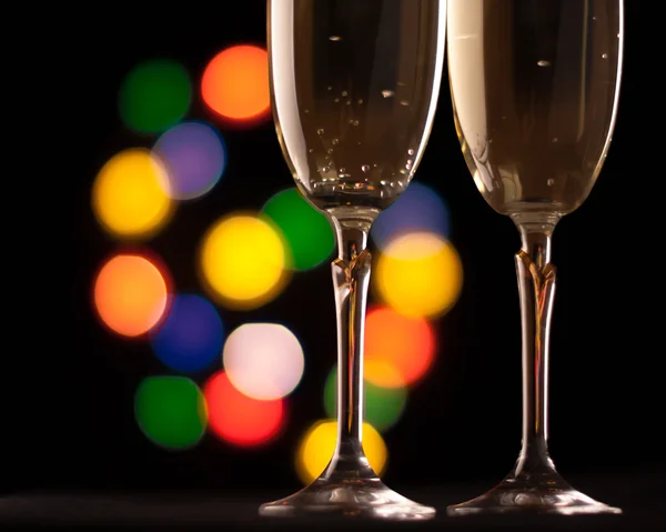 Due bicchieri di champagne tostatura contro bokeh luci sfondo — Foto Stock