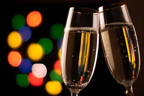 Zwei Gläser Champagner, die vor Bokeh-Lichtern anstoßen — Stockfoto