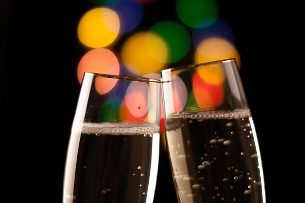 Two glasses of champagne toasting against bokeh lights background — Stock Photo, Image