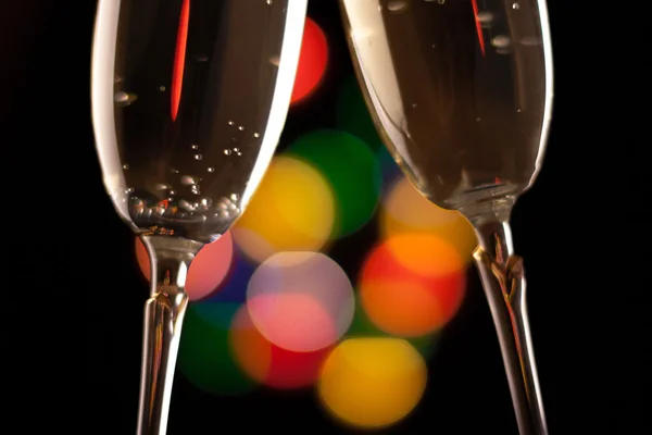 Two glasses of champagne toasting against bokeh lights background — Stock Photo, Image