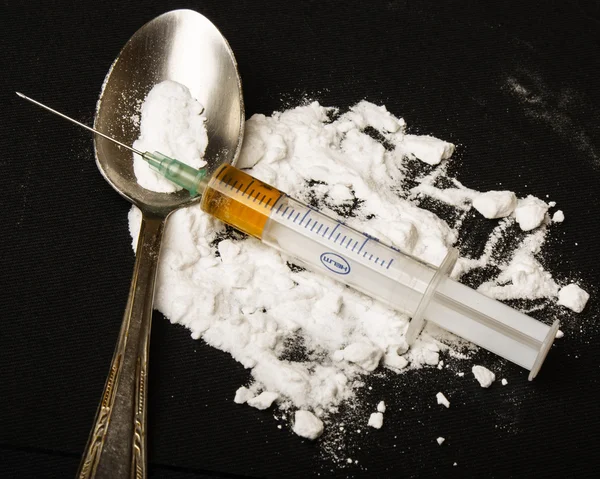 Drogenspritze und gekochtes Heroin auf Löffel — Stockfoto