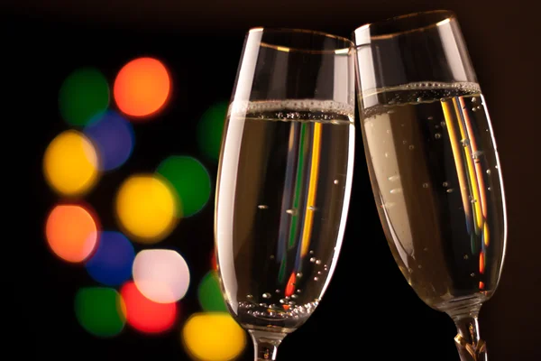 Due bicchieri di champagne tostatura contro bokeh luci sfondo — Foto Stock