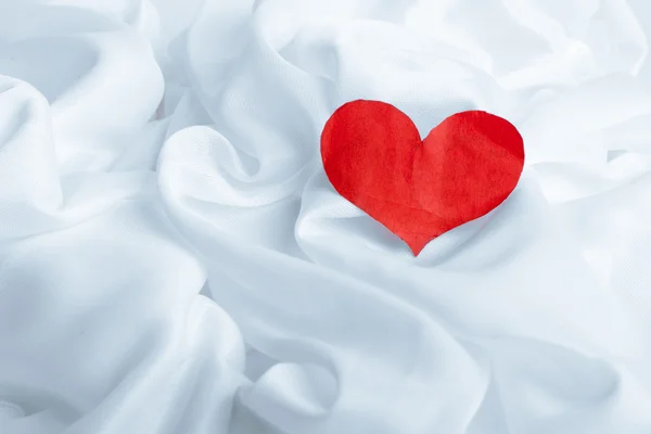 Red heart on white silk fabric — Stock Photo, Image