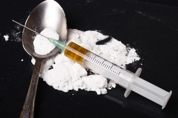 汤匙上的药物注射器和熟海洛因 — 图库照片