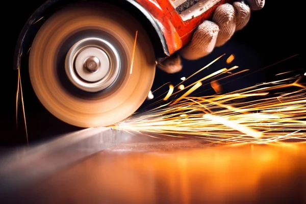 Arbetare skär metall med kvarn. Gnistor vid slipning av järn — Stockfoto