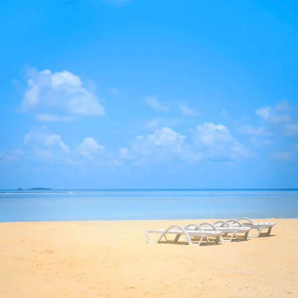 Sedie da spiaggia sulla spiaggia di sabbia bianca con bel cielo azzurro nuvoloso — Foto Stock
