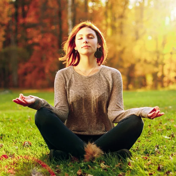 Krásná mladá dívka meditující v podzimním parku — Stock fotografie