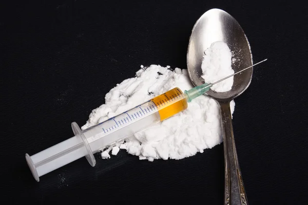 Drogenspritze und gekochtes Heroin auf Löffel — Stockfoto