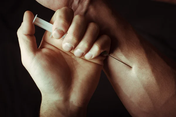 Hand met heroïne spuiten. Close-up foto. — Stockfoto