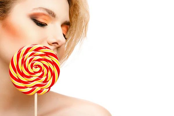 Woman licks candy with beautiful make-up isolated on white background — Stock Photo, Image