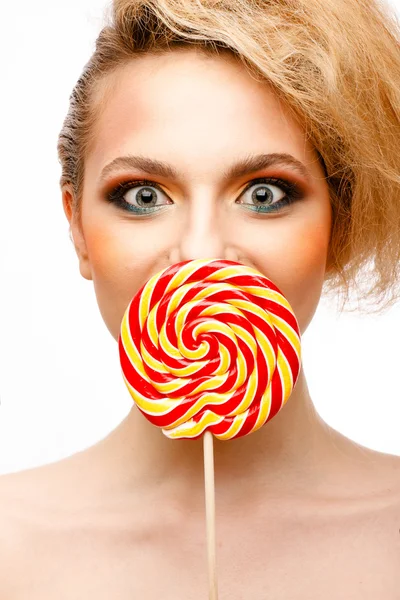 Женщина лижет конфеты с красивым макияжем изолированы на белом фоне — стоковое фото