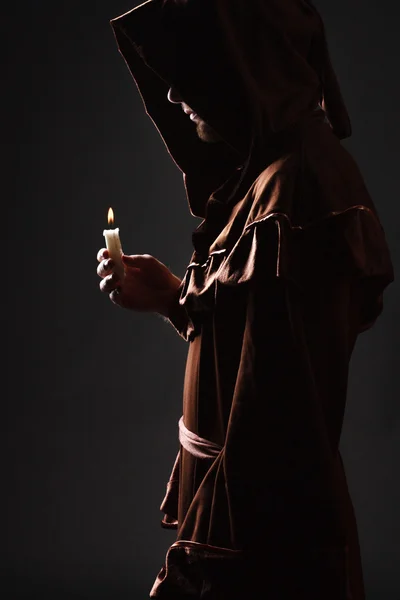Чарівник в чорній накидці зі свічкою — стокове фото