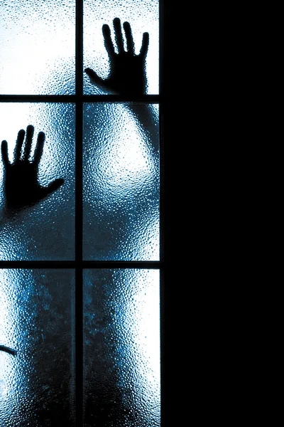 Испуганный мальчик за стеклянной дверью — стоковое фото