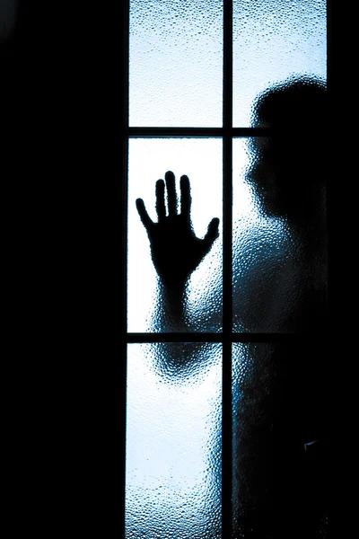Przerażony chłopiec za szklane drzwi — Zdjęcie stockowe