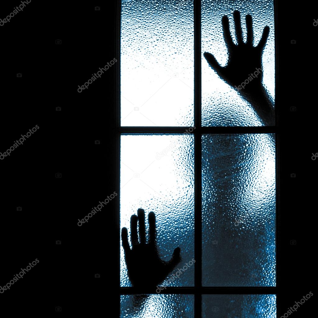 Scared boy behind glass door