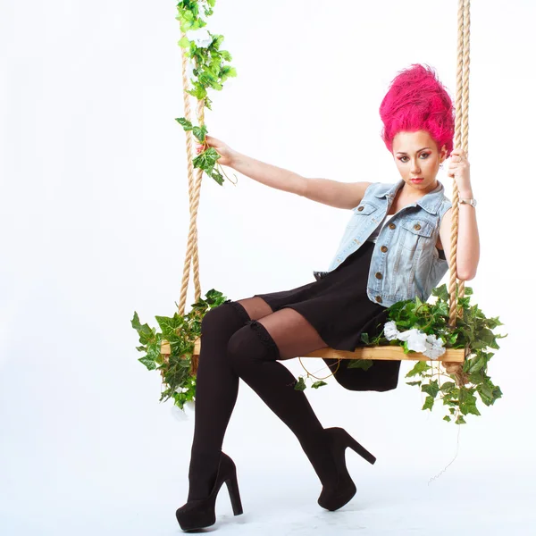 Girl with pink hair shakes on a swing — Stock Photo, Image
