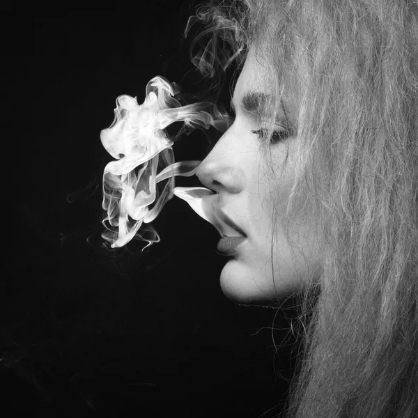 Buio e macchiato colpo di una giovane donna fumare — Foto Stock