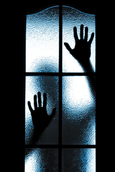 Scared boy behind glass door — Stock Photo, Image