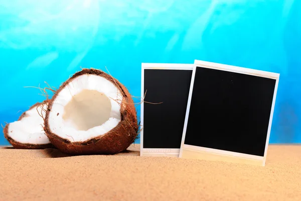 Coco picado e fotomoldura na areia — Fotografia de Stock