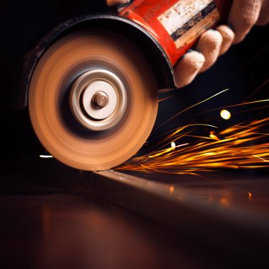 Öğütücüyle metal kesen bir işçi