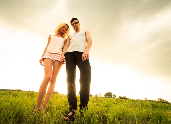 Couple walking through the field and holding hands — Stock Photo, Image