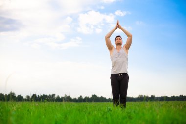 młody człowiek robi joga w parku