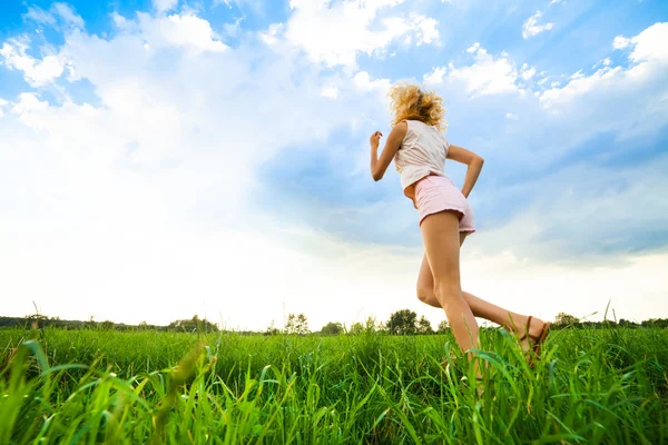 Jovencita corriendo por un camino rural al atardecer — Foto de Stock