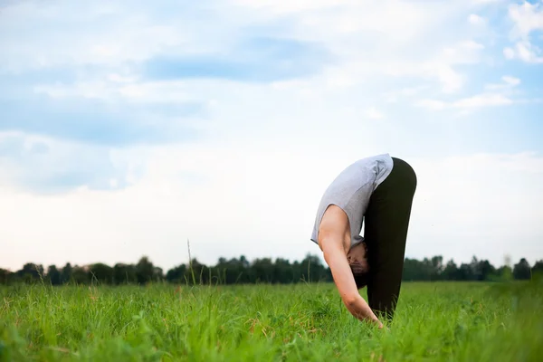 Ung man gör yoga i park — Stockfoto