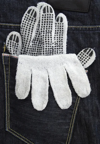 Working glove in the back pocket of old used jeans — Stock Photo, Image