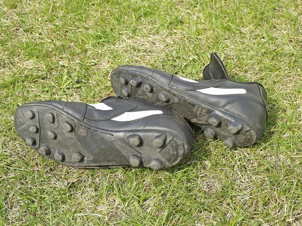 在高高的草丛中的足球鞋 — 图库照片