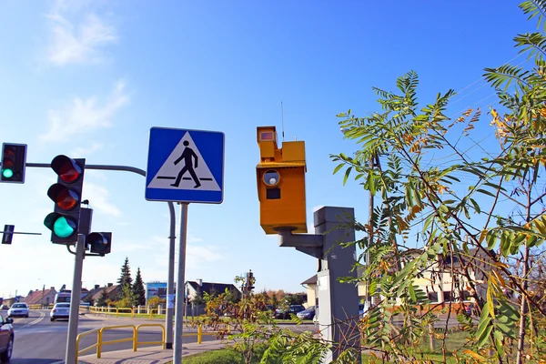 Traffic speed monitoring camera, against a bright blue sky