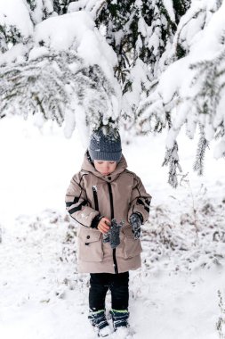 Çocuk ağacın altında, karda.