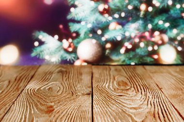 Noel ağacının arkasındaki ahşap masa, şenlikli bir arka plan.
