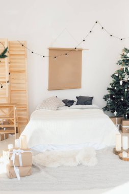 Yatağın üstünde boş bir poster, yılbaşı dekorasyonu.