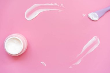 yüz kremi ve pembe arka planda fırça, vücut bakımı konsepti, düz uzanma
