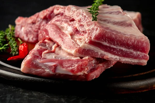 Baharatlı çiğ domuz kaburgası ve ahşap arka planda kekik.