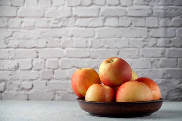 Manzanas rojas maduras en una mesa de cocina contra un fondo de pared de ladrillo — Foto de Stock